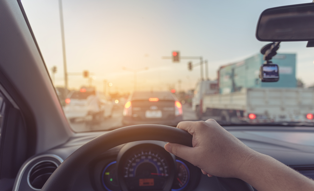 view from the drivers side of a car with a hand on the wheel