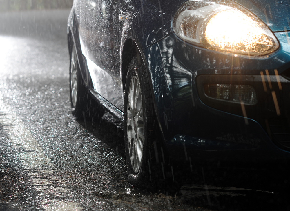 side view of car driving in severe rain