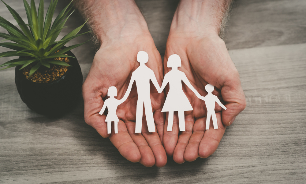 hand holding cutout of family shapes