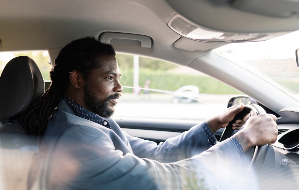 african american man in car commuting to work