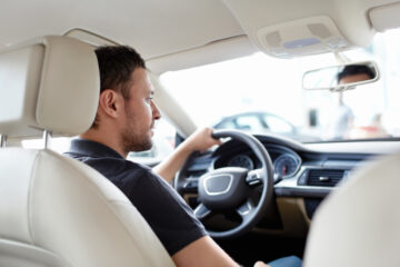 caucasian man behind the wheel of car