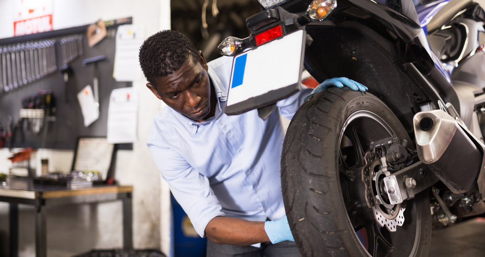 african american man inspecting motorcycle